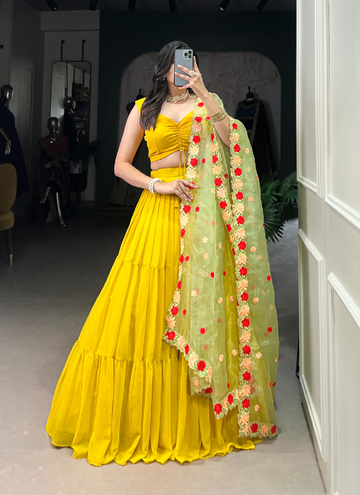 Haldi ceremony ruffle georgette lehenga choli paired with floral organza dupatta.